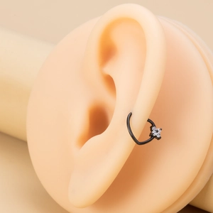 Macro shot of black flower cartilage hoop with white zircon stones on ear model