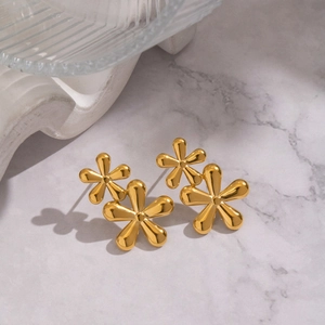 Close-up of golden floral stud earrings with layered petal design and polished finish
