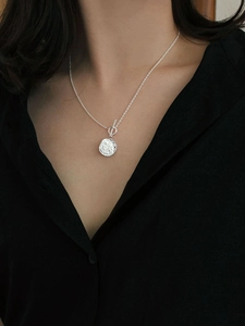 Macro view of sterling silver toggle clasp necklace with a hammered round pendant