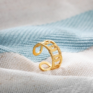 Detailed macro view of an 18K gold-plated adjustable chain-link ring set on fabric