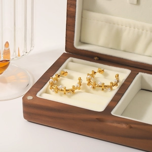 Golden stainless steel C-shaped earrings with pearls in a velvet jewelry box