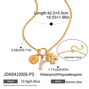 Detailed view of golden stainless steel necklace with coin, letter L and clover charms