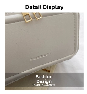 Detail showing dual gold zippers and embossed text on a white faux leather bag