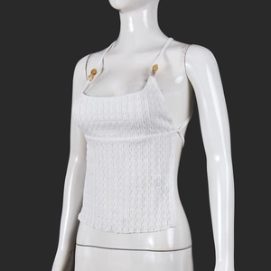 Detail of white knit halter top featuring crinkled texture and amber decorative rings