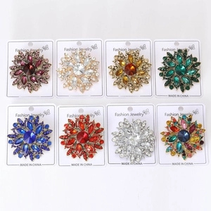 Detailed macro view of eight colorful crystal flower brooches in various gemstone colors