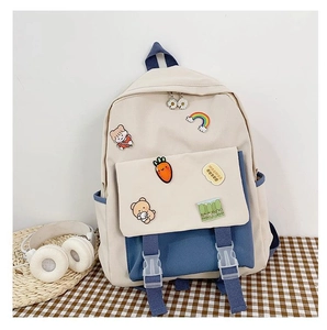 Close-up of cream and light blue canvas backpack with decorative badges and buckle