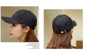 Detail of adjustable silver metal buckle and blue embroidery on black cotton baseball cap