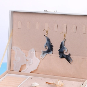 Detail view of face silhouette resin earrings with marble pattern and DIY silicone mold
