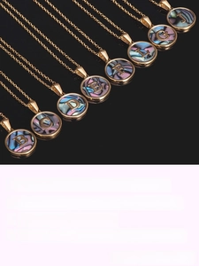 Detailed view of 18K gold plated round shell initial necklaces with engraved alphabet charms