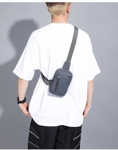 Rear view of a minimalist grey waterproof chest bag worn over a white T-shirt