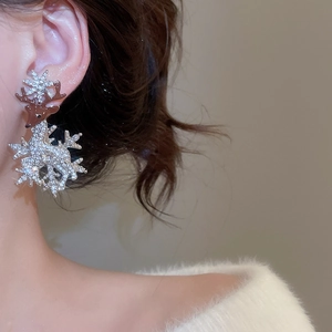 Detail of Christmas reindeer earrings with rhinestones on silver pin worn by a model