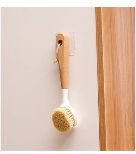 Long handle wooden bath brush hanging on a white wall for storage and bathroom organization