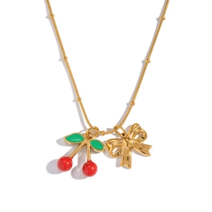 Detail of 18K gold necklace with cherry pendant and bow charm on thin chain