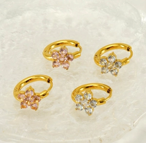 Détail de boucles d'oreilles flocon en acier plaqué or 18K avec zircons roses et blancs
