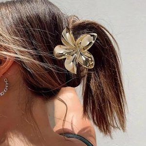 Dettaglio del fermaglio a fiore bauhinia dorato da 8cm su una coda di cavallo al sole