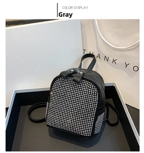 Detailed view of gray mini backpack with shimmering rhinestones and leather handle