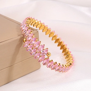 Detailed macro view of pink marquise gems set on a gold-plated titanium bracelet