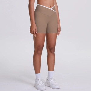 Detail of high-waisted khaki yoga shorts with white cross-waist design and peach lift effect