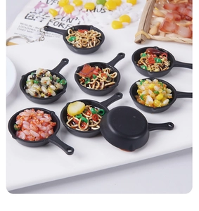 Close-up of miniature pan food models showing detailed fried rice and noodles charms