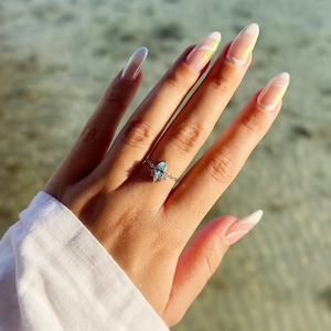 Detail of water drop shaped aquamarine ring with micro pavé diamonds on finger