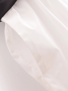 Detailed close-up of white midi dress side pockets with black waistband contrast detail