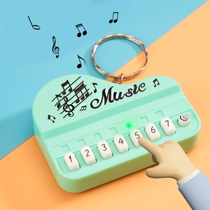Mini piano keychain toy in mint green with functional buttons and musical notes