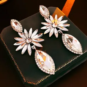 Luxury flower drop earrings with marquise crystals on a vintage green leather box