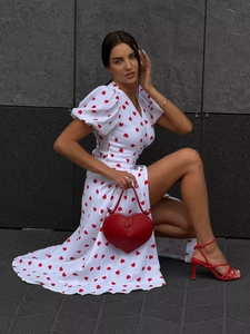 Detailed close-up of white cotton dress with red heart print and puff sleeves