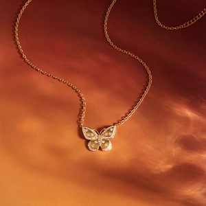 Collier élégant avec pendentif papillon doré et strass brillants sur velours orange