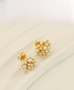 Macro shot of 18k gold plated stainless steel sunflower pearl earrings with butterfly back