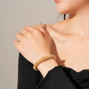 Gros plan détaillé d'un bracelet jonc doré orné de zircons blancs étincelants