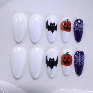Halloween almond press-on nails with bat, pumpkin, and spider web festive designs