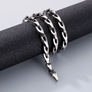 Détail du bracelet chaîne en os de serpent argenté avec texture d'écailles sur un support