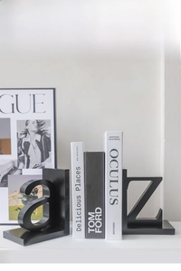 Detail view of black matte minimalist A and Z letter bookends on a modern white desk