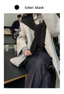 Detail of black ribbed knit scarf shawl layered over a classic herringbone wool coat