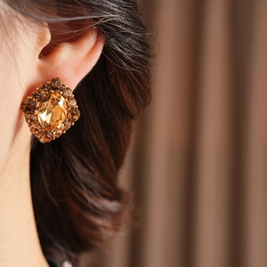 Détail de boucles d'oreilles carrées vintage dorées avec pierre précieuse ambre