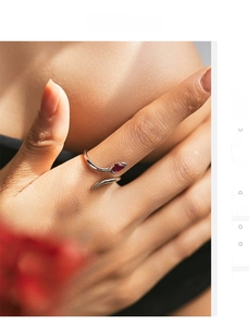 Detail of silver snake-shaped adjustable ring featuring a pear-cut red gemstone
