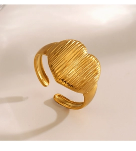 Macro shot of gold-plated heart ring with vertical striped texture and adjustable band