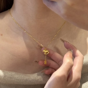 24K gold plated rocking horse necklace on woman in beige knit sweater close-up