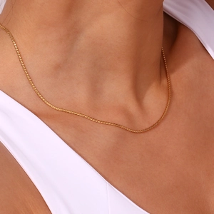 Close-up of a minimalist 18K gold plated stainless steel snake chain necklace on neck