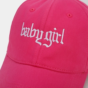 Close-up of babygirl gothic embroidery on hot pink cotton twill baseball cap