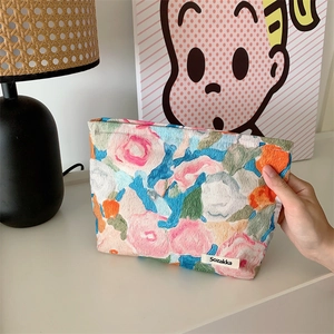 Close-up of artistic floral cotton makeup bag with woven Sozakka label and textured fabric