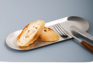 Macro detail of brushed stainless steel oval tray with smooth edges for food presentation