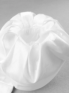 Detailed macro view of white puffy lantern sleeves with elegant pleated fabric texture