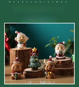 Close-up of mini resin Christmas figurines including Santa and reindeer on wooden base