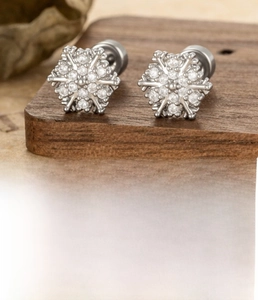 Macro shot of silver snowflake earrings with zirconia and titanium screw back details
