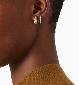 Macro shot of gold S925 sterling silver C-shaped stud earrings with micro-set zircon crystals