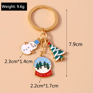 Detail of Christmas snowman and Xmas tree charms on a gold plated metal keychain