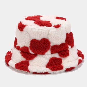 Close-up of soft white plush fabric and embroidered red heart pattern on bucket hat