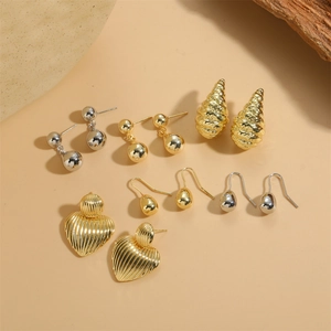 Collection of golden and silver earrings in heart, sphere and water drop shapes